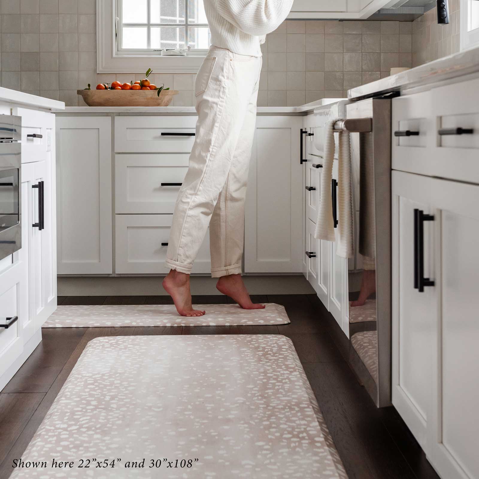 Fawn brown animal print standing mat shown in kitchen with woman standing at the counter opening a cabinet standing on her tippy toes