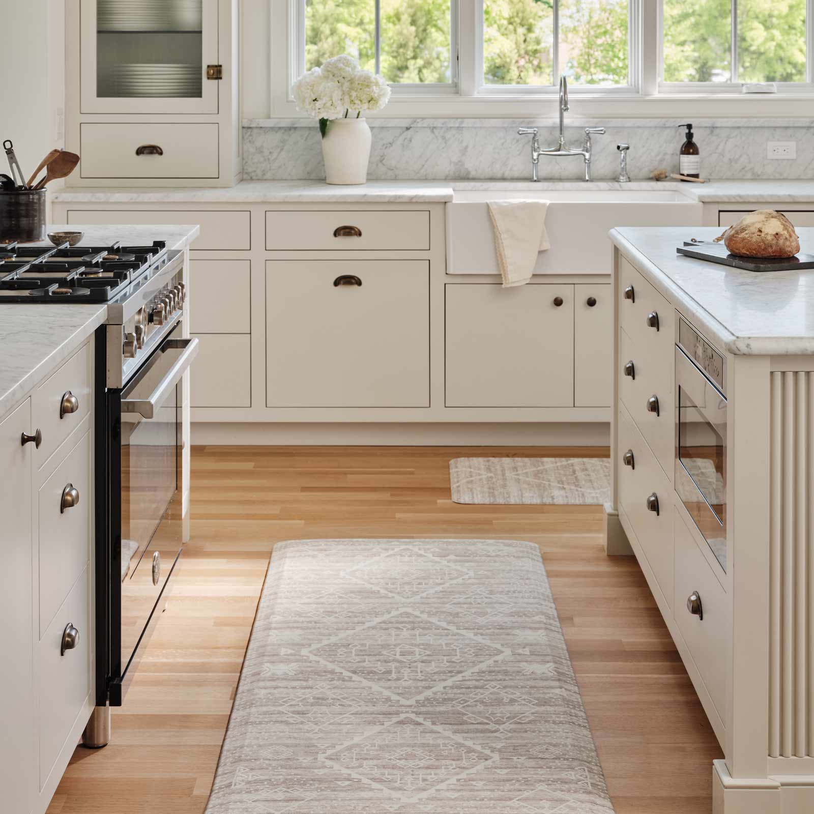 Ula driftwood neutral boho print standing mat shown in kitchen with size 30x72 in between an island and counter and size 22x54 in front of the sink