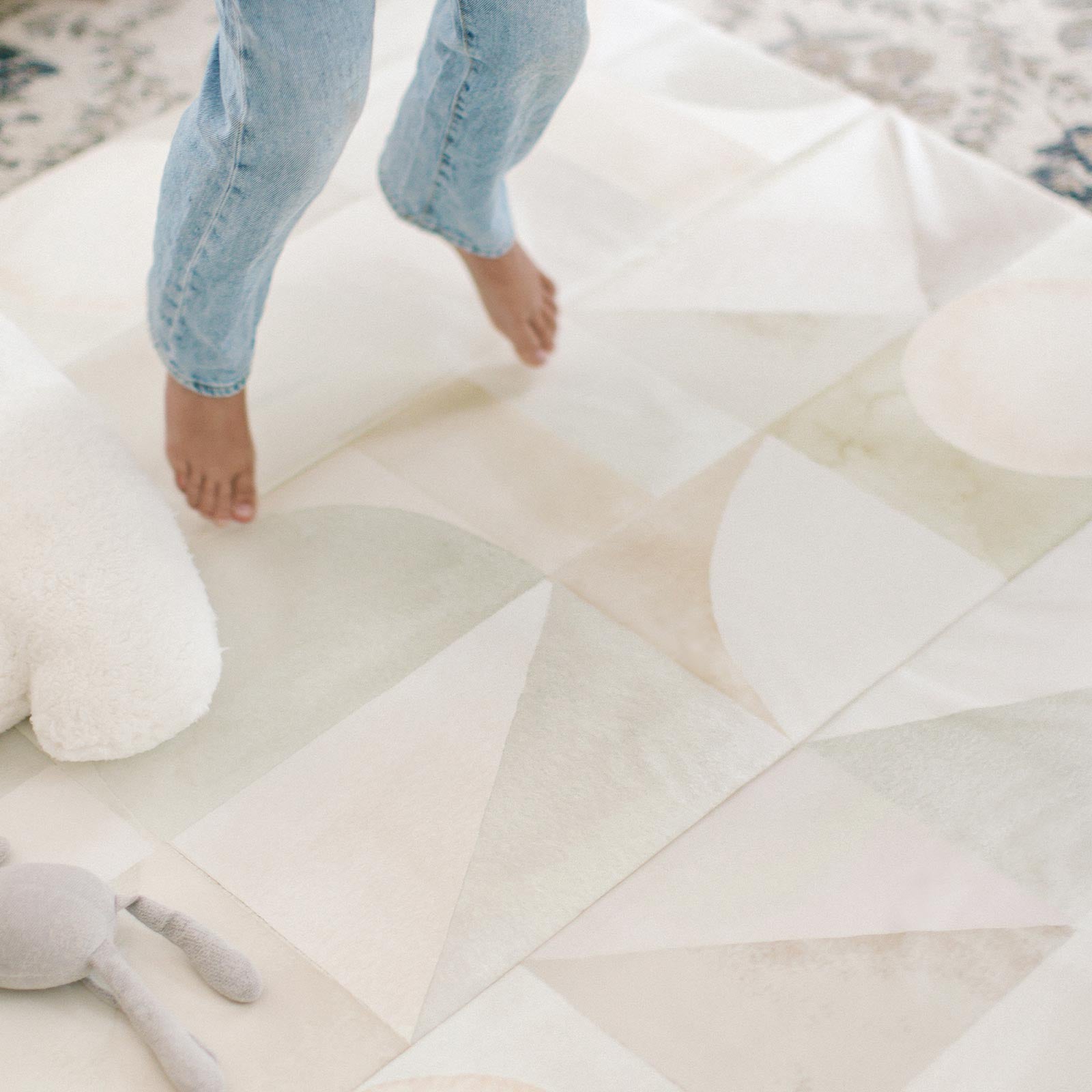 Boden stonewash neutral watercolor geometric print tumbling mat with childs feet jumping up off the mat