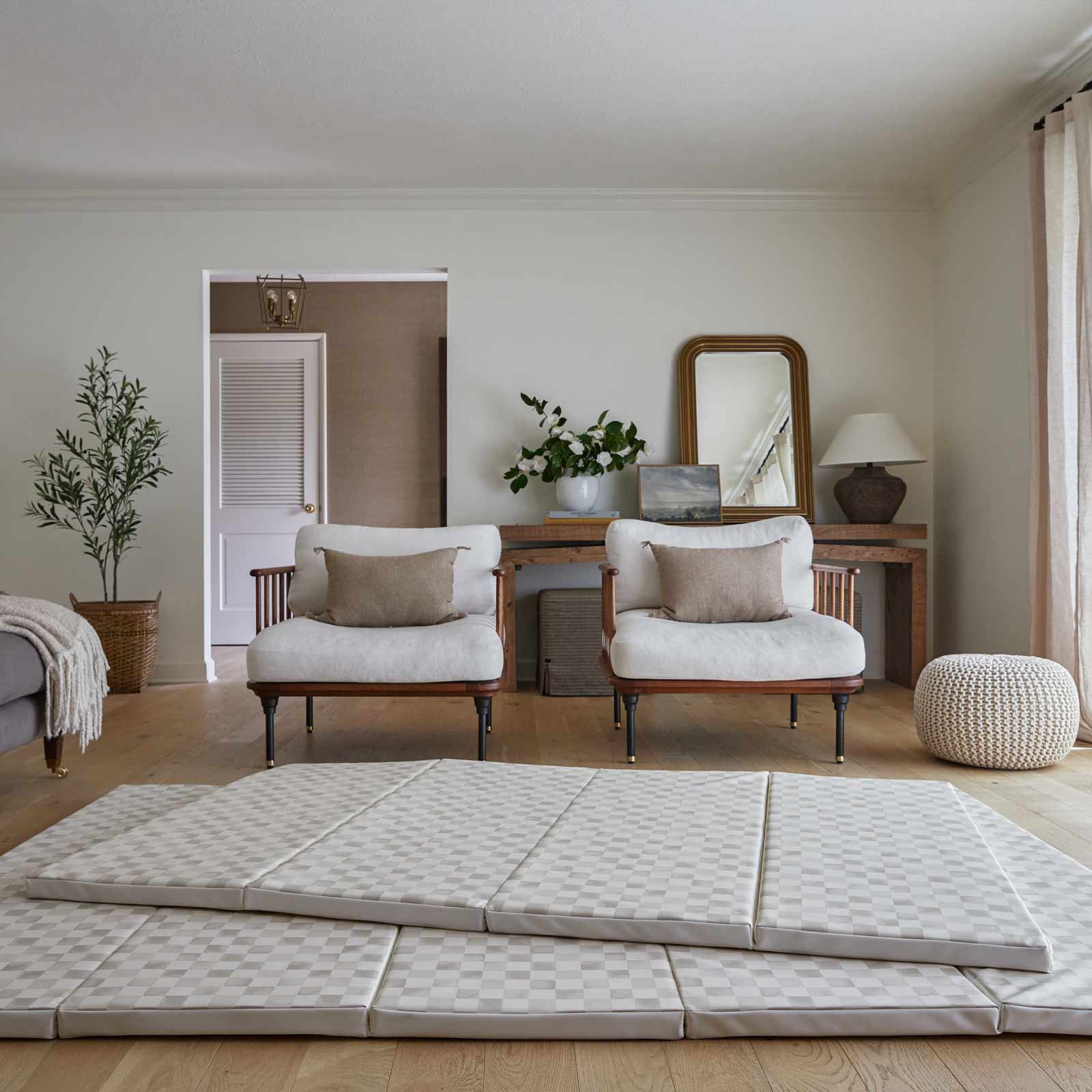 Almond neutral checker print tumbling mat shown in living room with sizes 4x6 stacked on top of size 5x7.5 