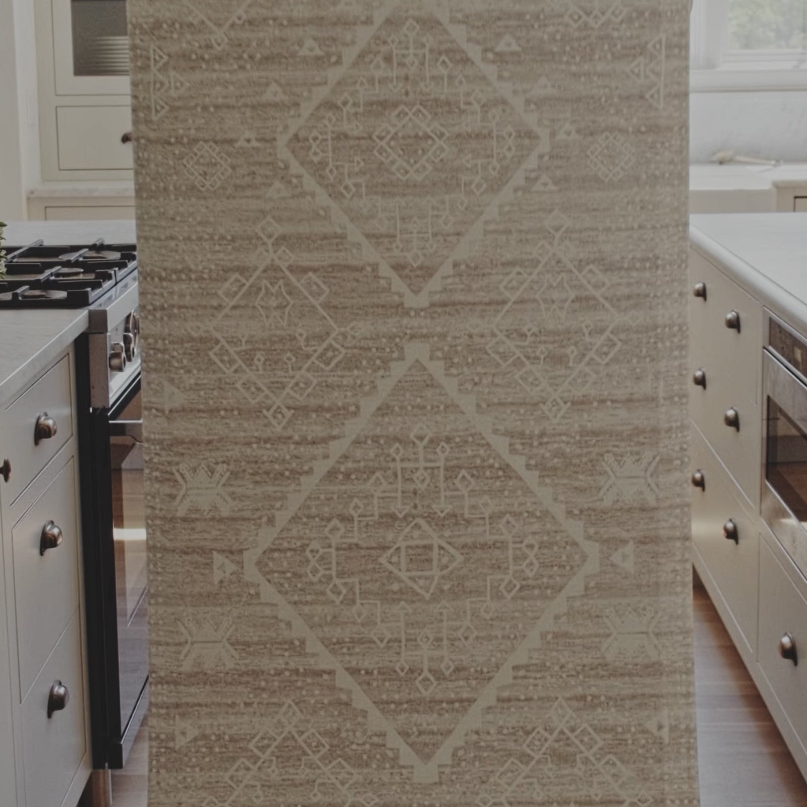 Video shot in a kitchen with woman placing Ula driftwood beige and white boho print standing mat on the floor. Then various shots of her walking on the mat and standing on the mat at the kitchen counter.