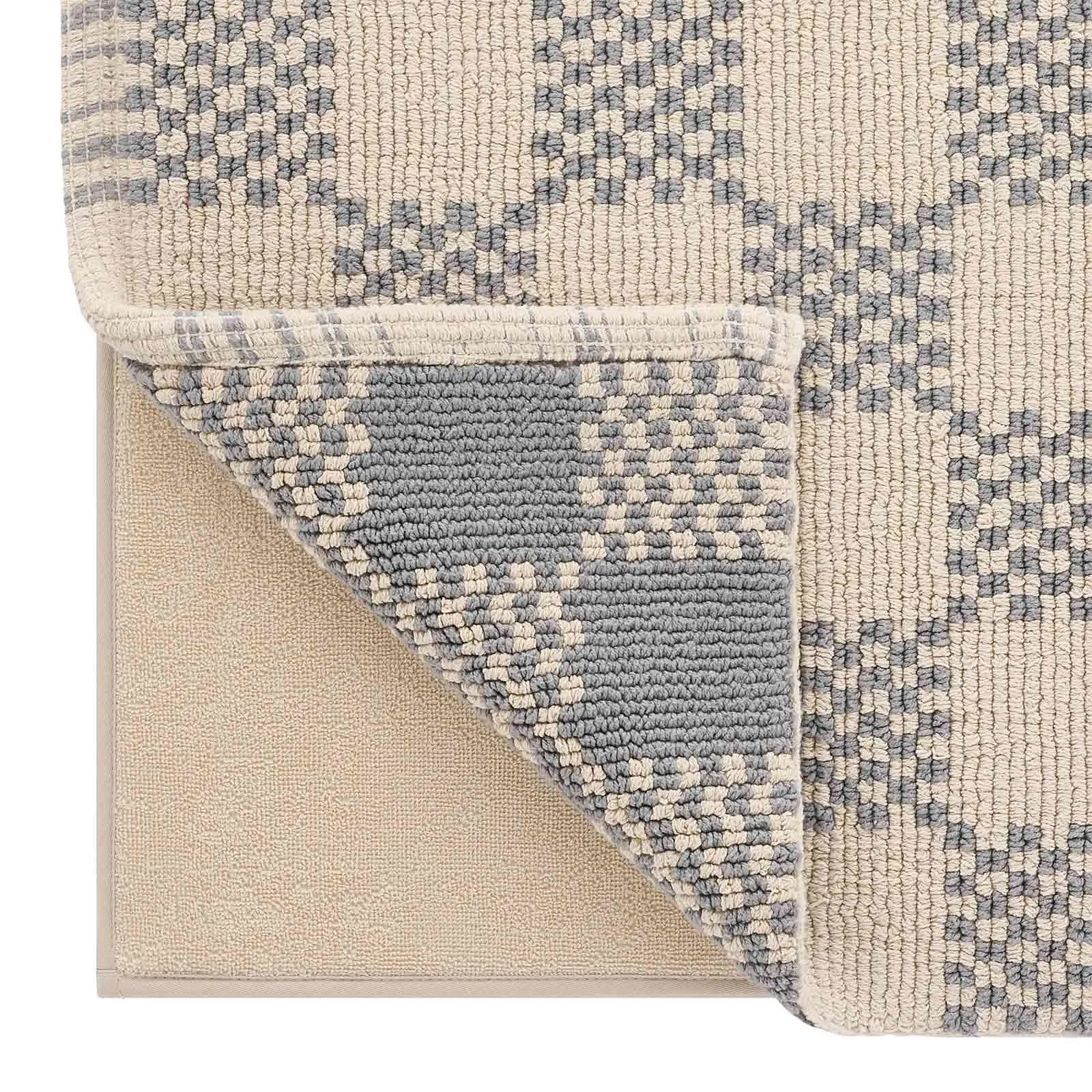 Bath mat in checker harbor gray print close up of a corner of the mat lifted up to show the memory foam liner underneath