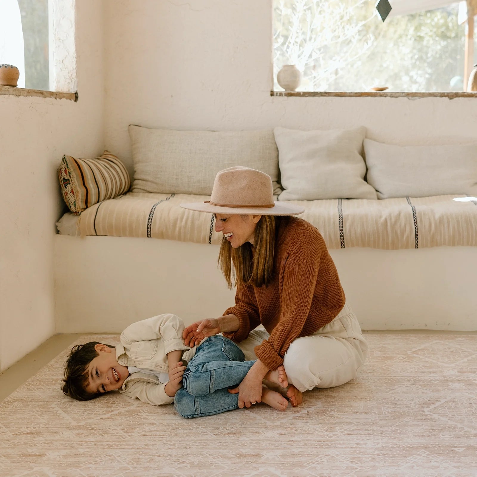 Ula Sienna neutral pink minimal boho pattern play mat in living room with Mom and son laughing and playing