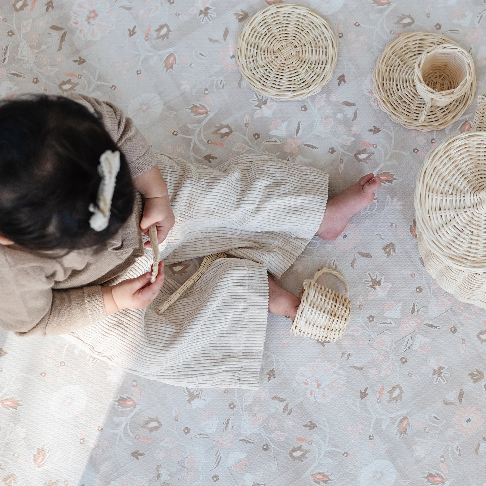 Linen beige and light pink floral baby play mat with baby sitting playing with tea set