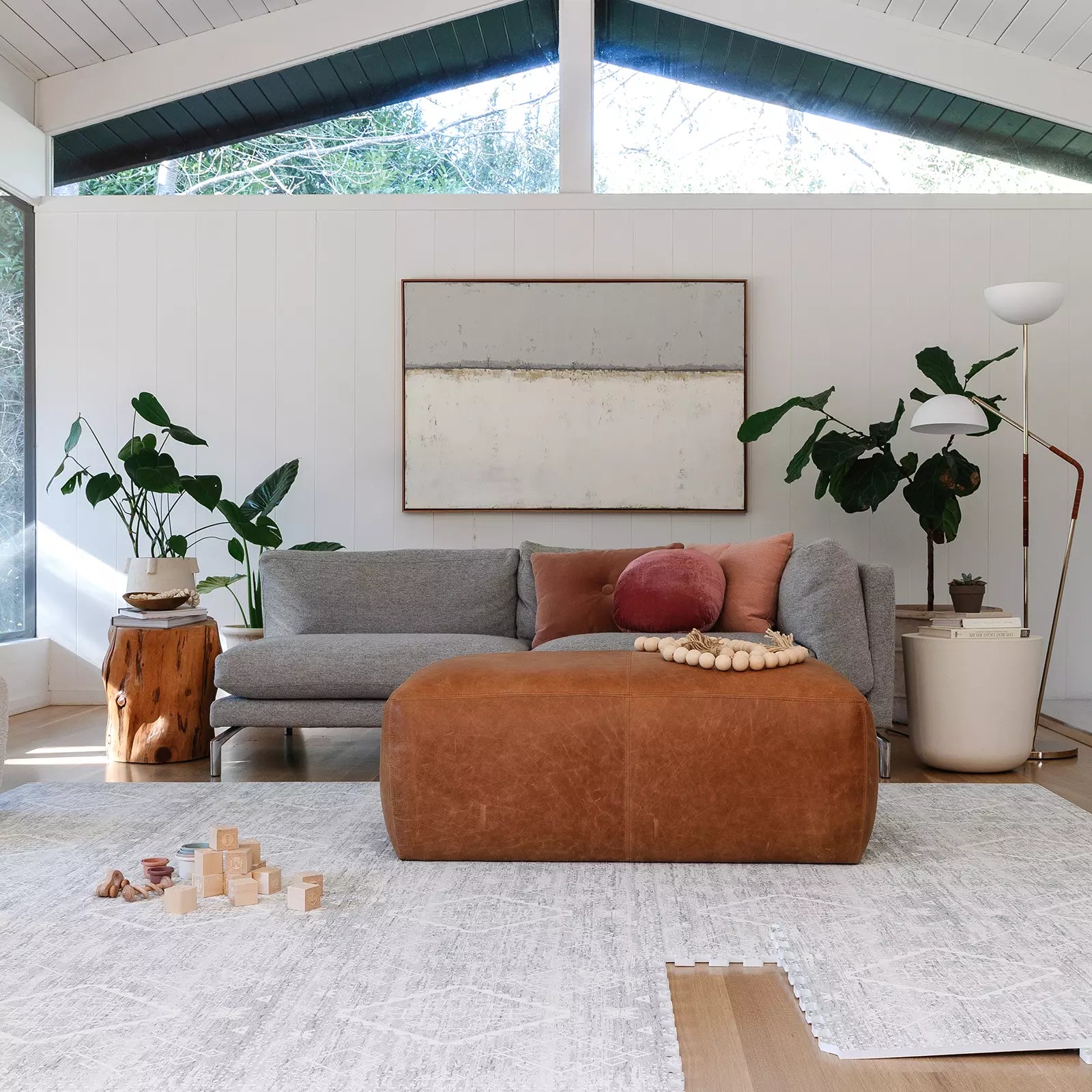 Gray and white minimal boho baby play mat shown in living room with baby toys and one tile exposed